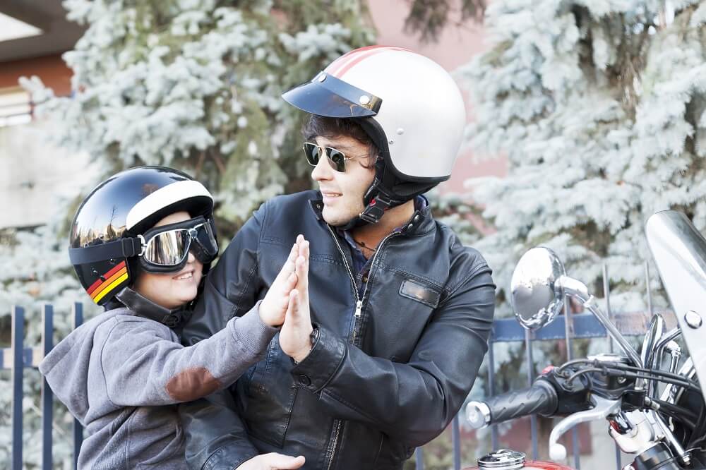 Father and son enjoying motorcycle rides with helmet.