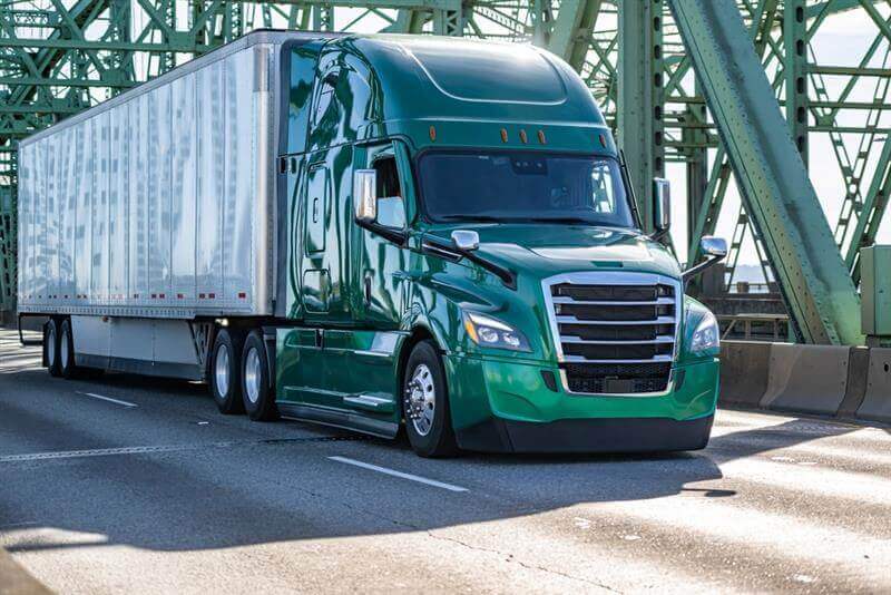 Green truck passing the brige.